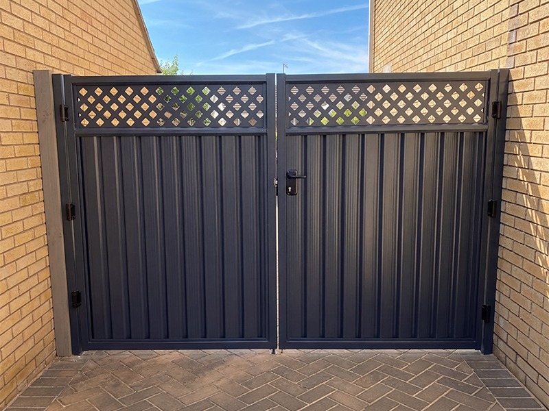 Timber-effect steel garden gate with climbing roses