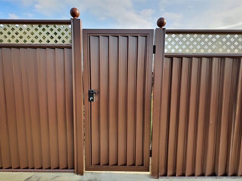 Timber-effect steel garden gate with climbing roses