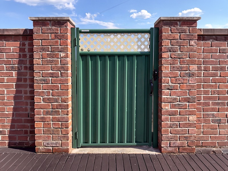 Timber-effect steel garden gate with climbing roses